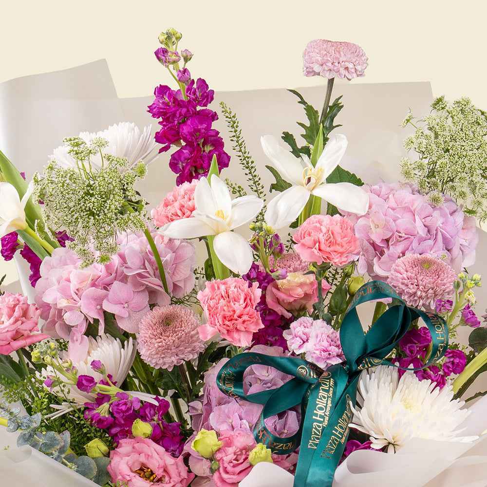 Plaza Hollandi x Qute fresh pink and purple floral bouquet wrapped in luxury white paper for baby girl gifts in Doha Qatar