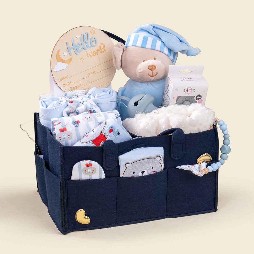 Plaza Hollandi x Qute navy blue diaper caddy filled with baby clothing, plush bear, and fresh blue floral bouquet for baby boy gifts in Doha Qatar