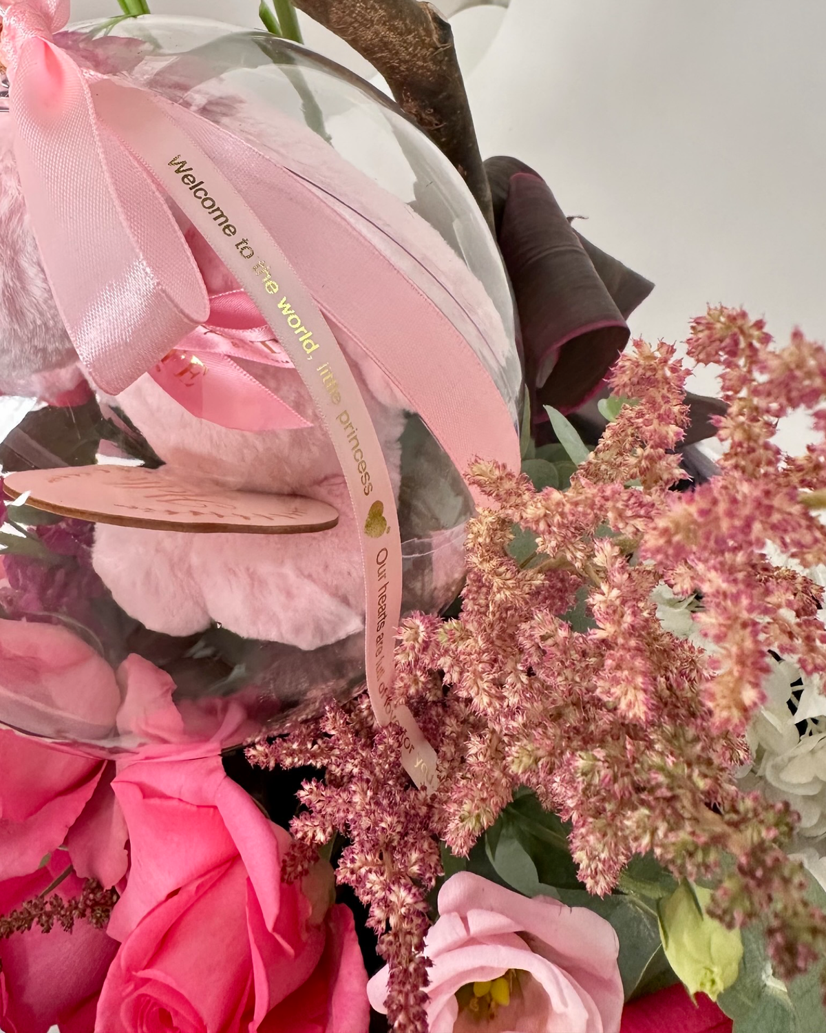 Same-day baby girl gift featuring a luxury floral box with pink roses and a "Hello Little One" acrylic keepsake bubble, designed for welcoming a newborn.