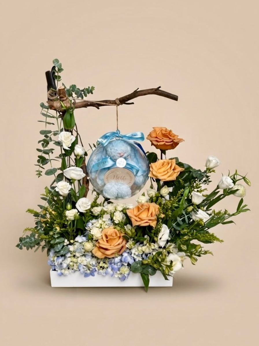 Same-day baby boy gift box featuring luxury champagne roses and an acrylic keepsake bubble with a blue plush toy for welcoming a newborn son.
