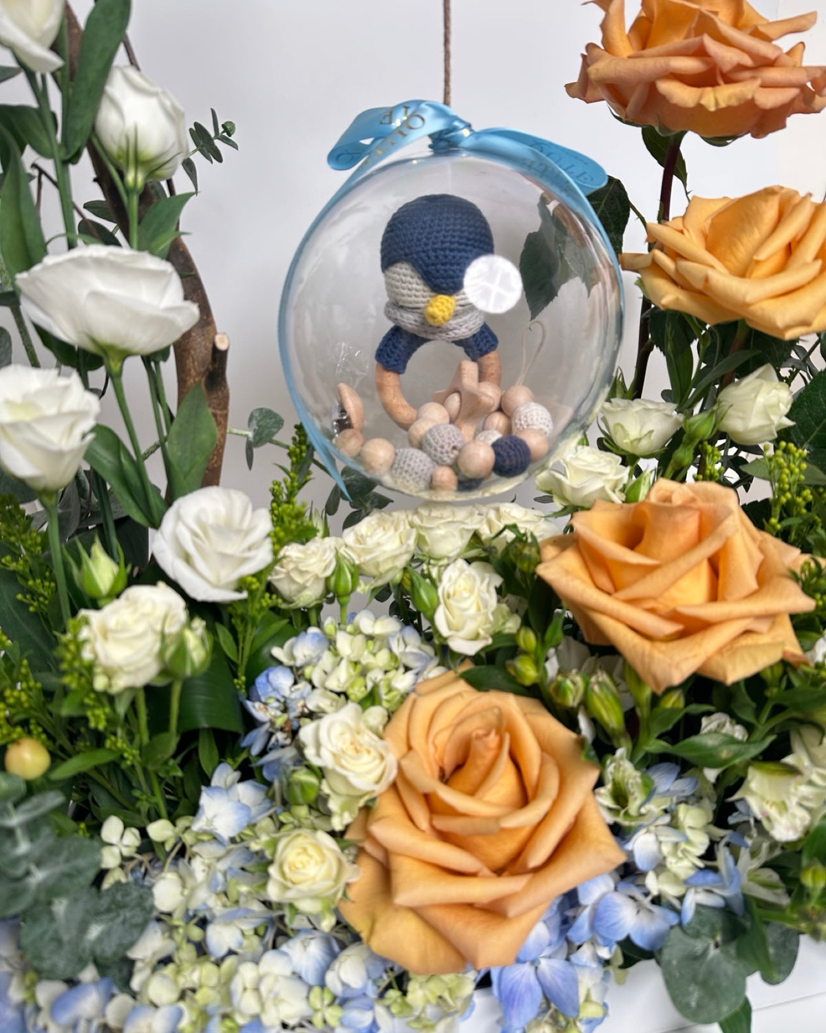 Special baby boy gift box featuring luxury champagne roses and an acrylic keepsake bubble packed with custom newborn items for welcoming a newborn son.