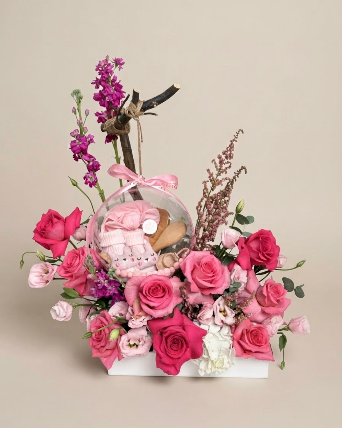 Same-day baby girl gift box featuring luxury pink roses and an acrylic keepsake bubble packed with practical newborn accessories for welcoming a new baby.   