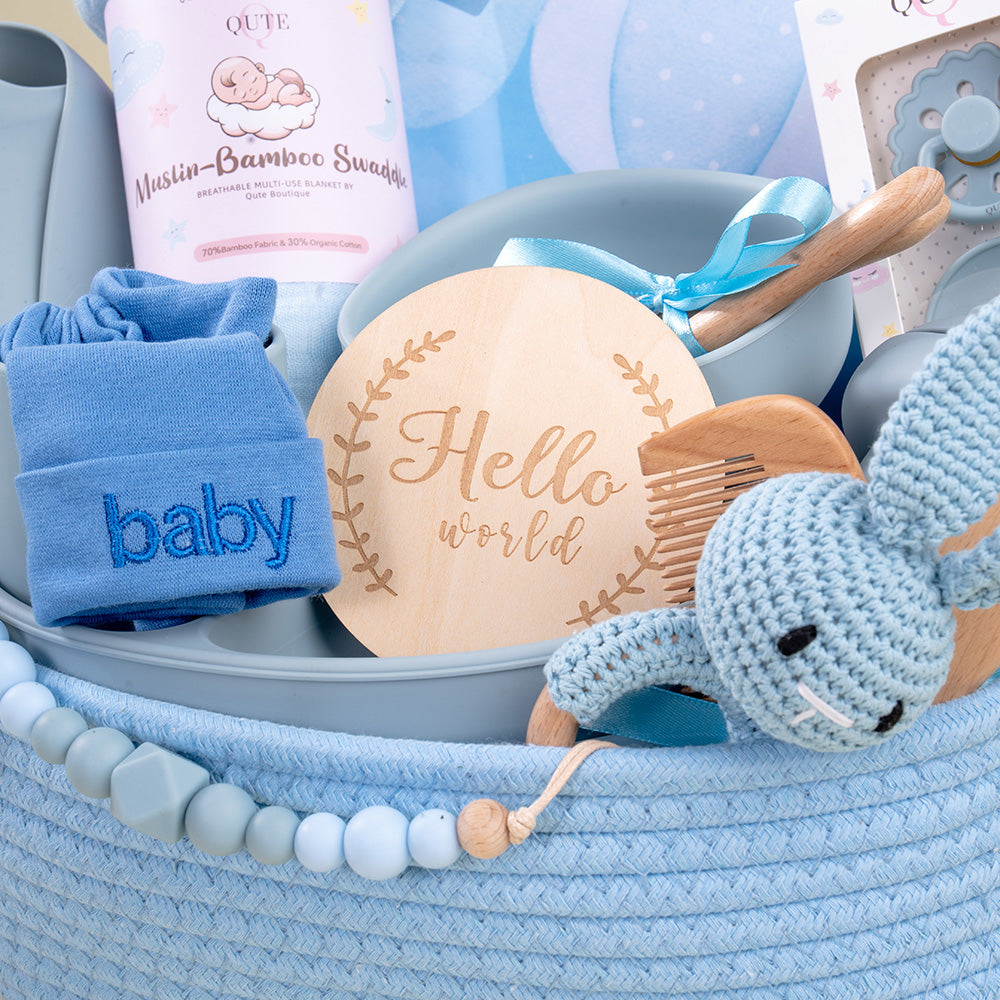 Plaza Hollandi x Qute long-lasting baby boy gift set in blue woven basket with silicone mealtime essentials and baby accessories in Doha Qatar