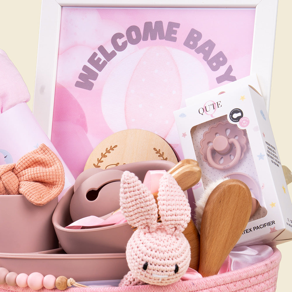 Plaza Hollandi x Qute luxury baby girl gift set in pink woven basket with silicone feeding tableware and newborn accessories in Doha Qatar