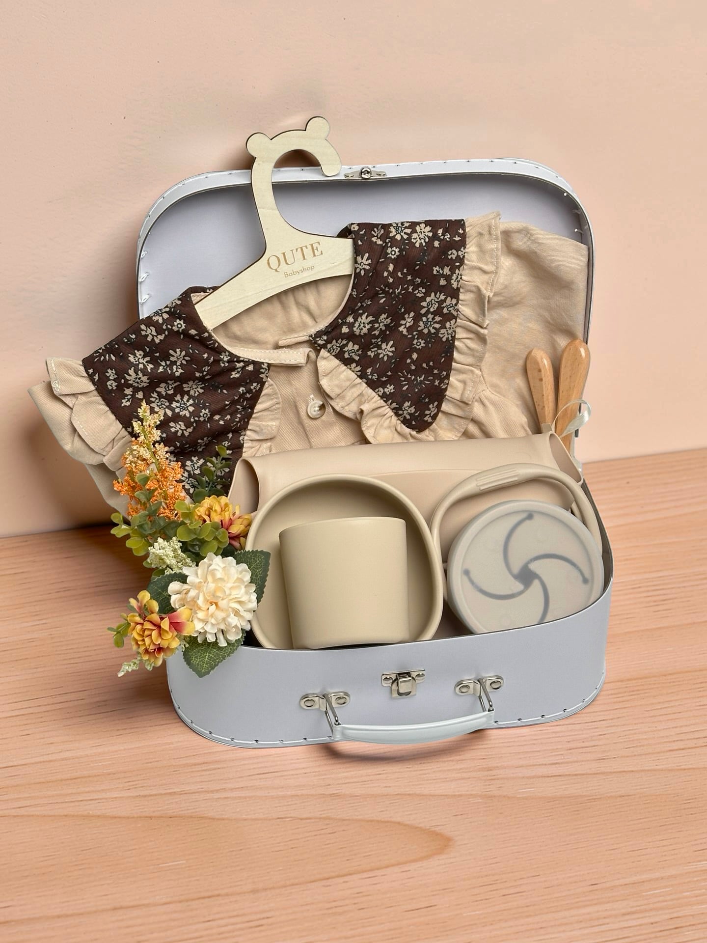 Luxury silicone baby feeding set and baby girl gift box in white trunk hamper with silicone bowl, cup, snack tub, wooden spoons, baby outfit, and floral bouquet by Qute Gifts Doha Qatar