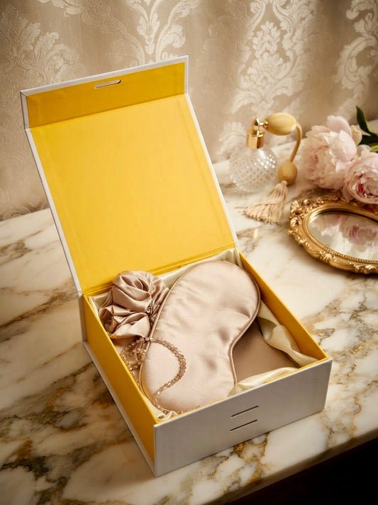 Luxury 100% mulberry silk self-care gift set in gold by Qute Qatar, featuring a gold silk pillowcase, eye mask, and scrunchie inside a luxury gift box for postpartum and birthday gifting in Doha.