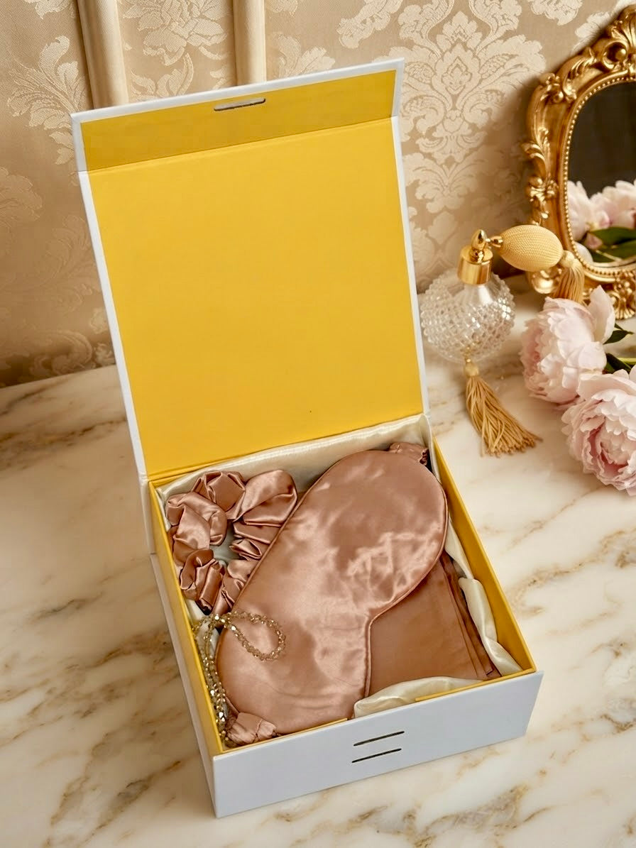 Luxury 100% mulberry silk self-care gift set in rose gold by Qute Qatar, featuring a rose gold silk pillowcase, eye mask, and scrunchie inside a luxury gift box for postpartum and birthday gifting in Doha.