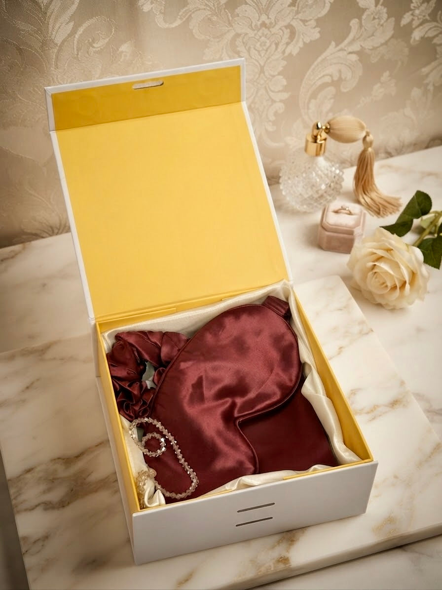 Luxury 100% mulberry silk self-care gift set in ruby red by Qute Qatar, featuring a ruby silk pillowcase, eye mask, and scrunchie inside a luxury gift box for postpartum and birthday gifting in Doha.