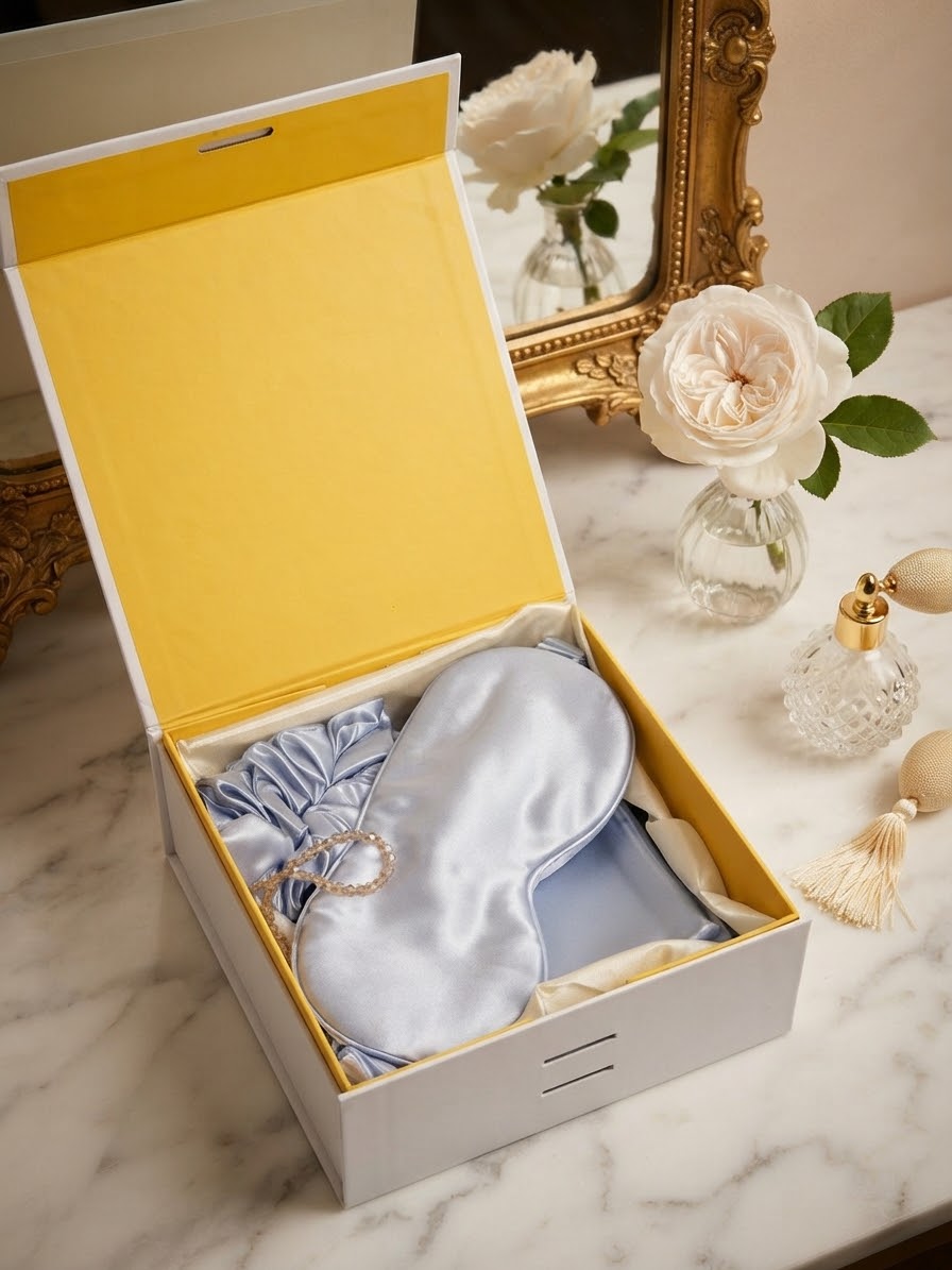 Luxury 100% mulberry silk self-care gift set in sky blue by Qute Qatar, featuring a sky blue silk pillowcase, eye mask, and scrunchie inside a luxury gift box for postpartum and birthday gifting in Doha.