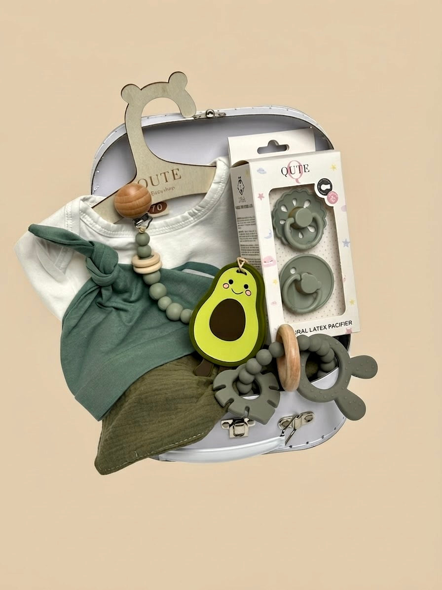Luxury newborn baby gift set in a white keepsake suitcase by Qute Qatar, featuring a 3-6 months sage green outfit, avocado teether, pacifiers, and teething accessories for delivery in Doha.