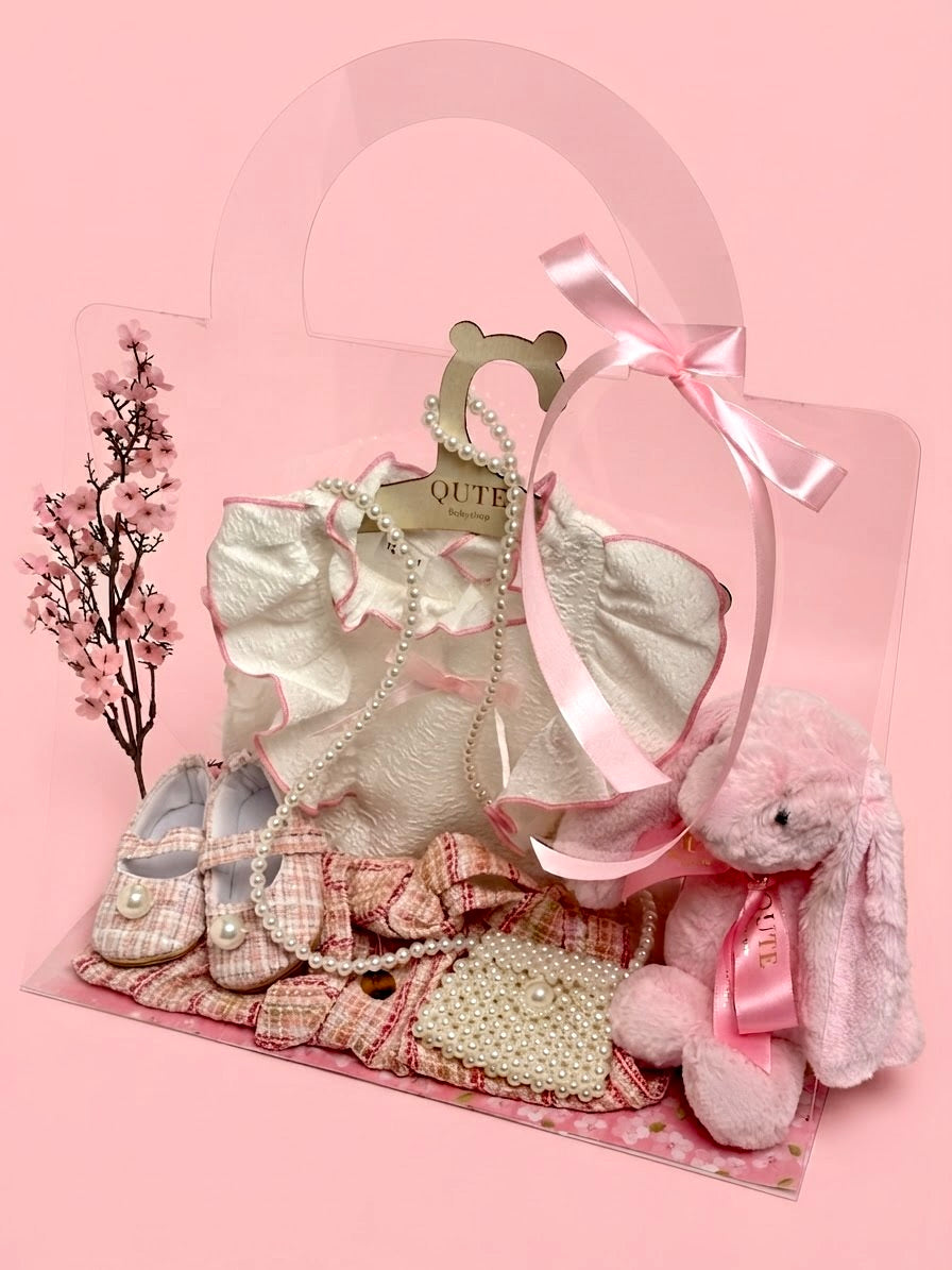 Luxury baby girl gift set for 12-18 months by Qute Qatar, featuring a pink and gold tweed skirt outfit, matching shoes, pearl mini bag, and a plush pink bunny for delivery in Doha.