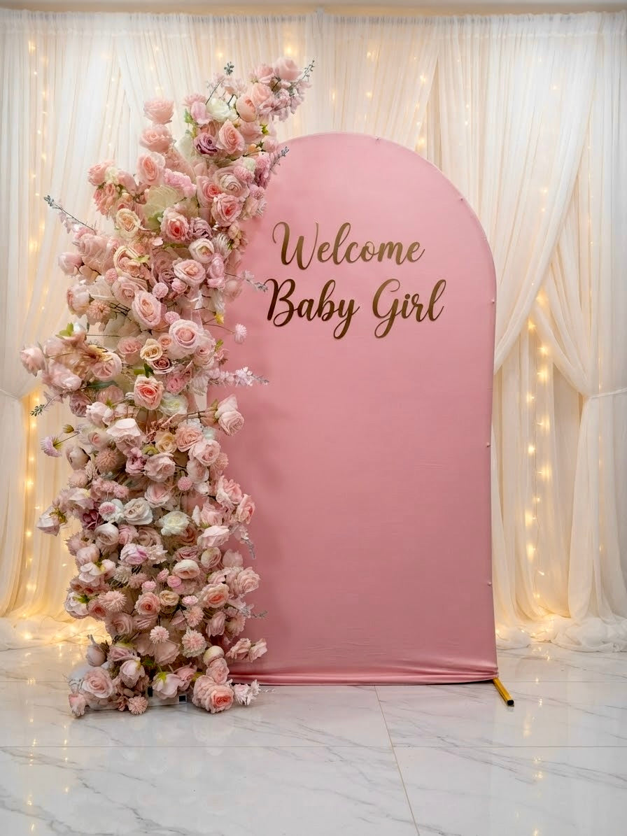 Luxury pink faux floral arch backdrop by Qute Qatar, featuring cascading artificial roses and an arched display designed for weddings, engagements, and baby showers in Doha.