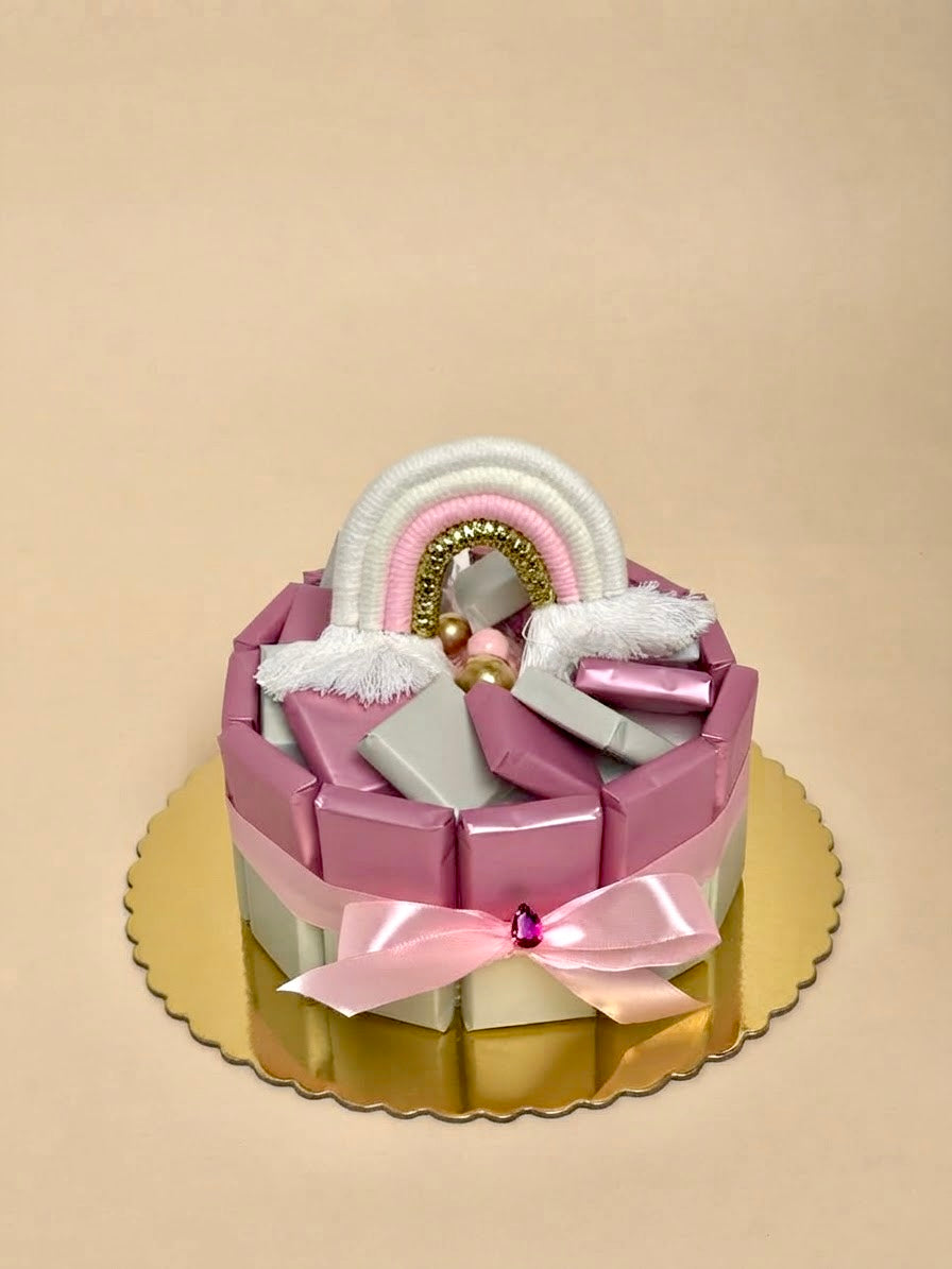 Unique luxury rainbow chocolate cake gift box by Qute Qatar, featuring individually wrapped chocolates, a handmade rainbow topper, and custom ribbons for birthdays and anniversaries in Doha.  