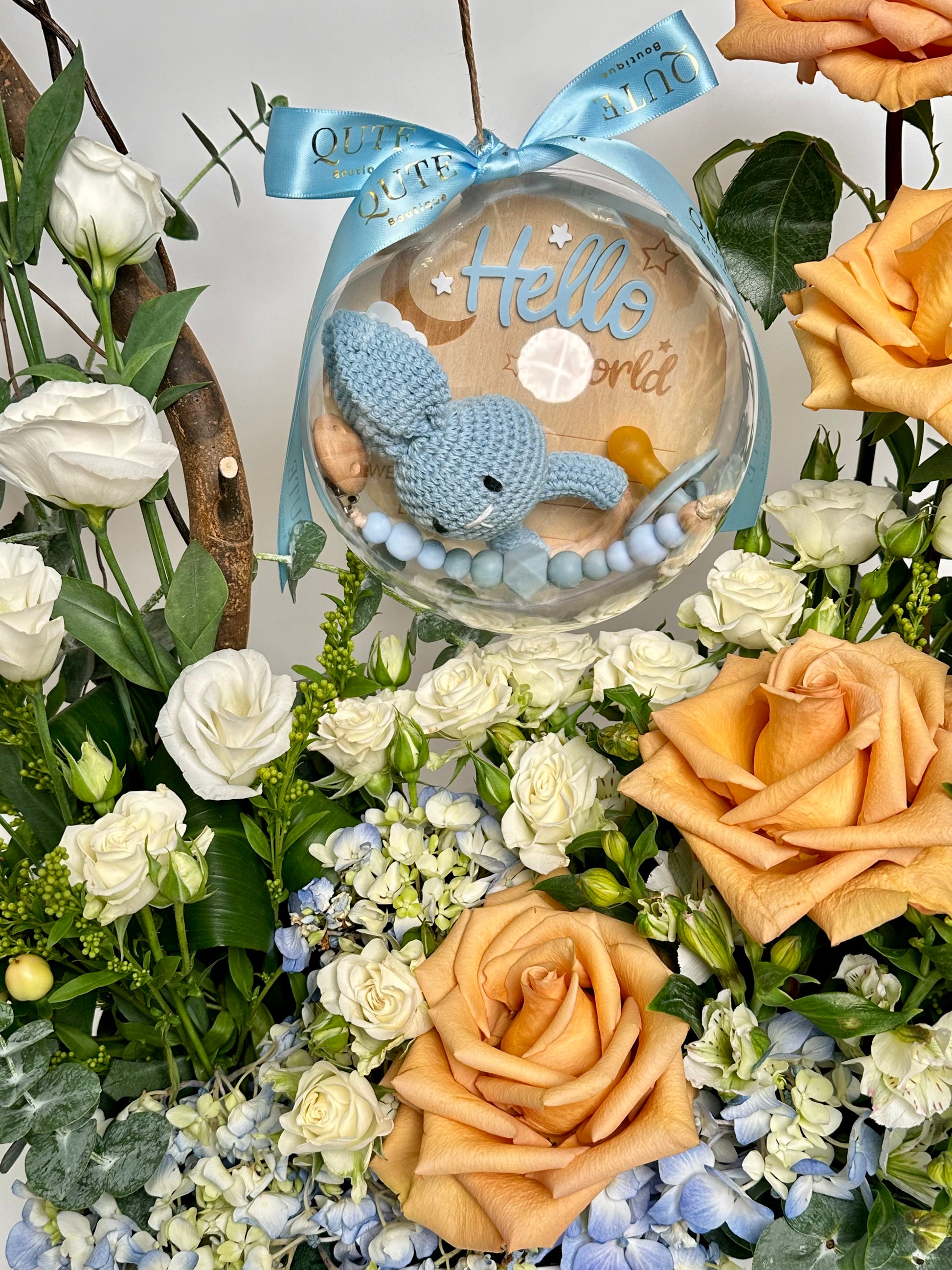 Special baby boy gift box featuring luxury champagne roses and an acrylic keepsake bubble packed with custom newborn milestone items for welcoming a newborn son.