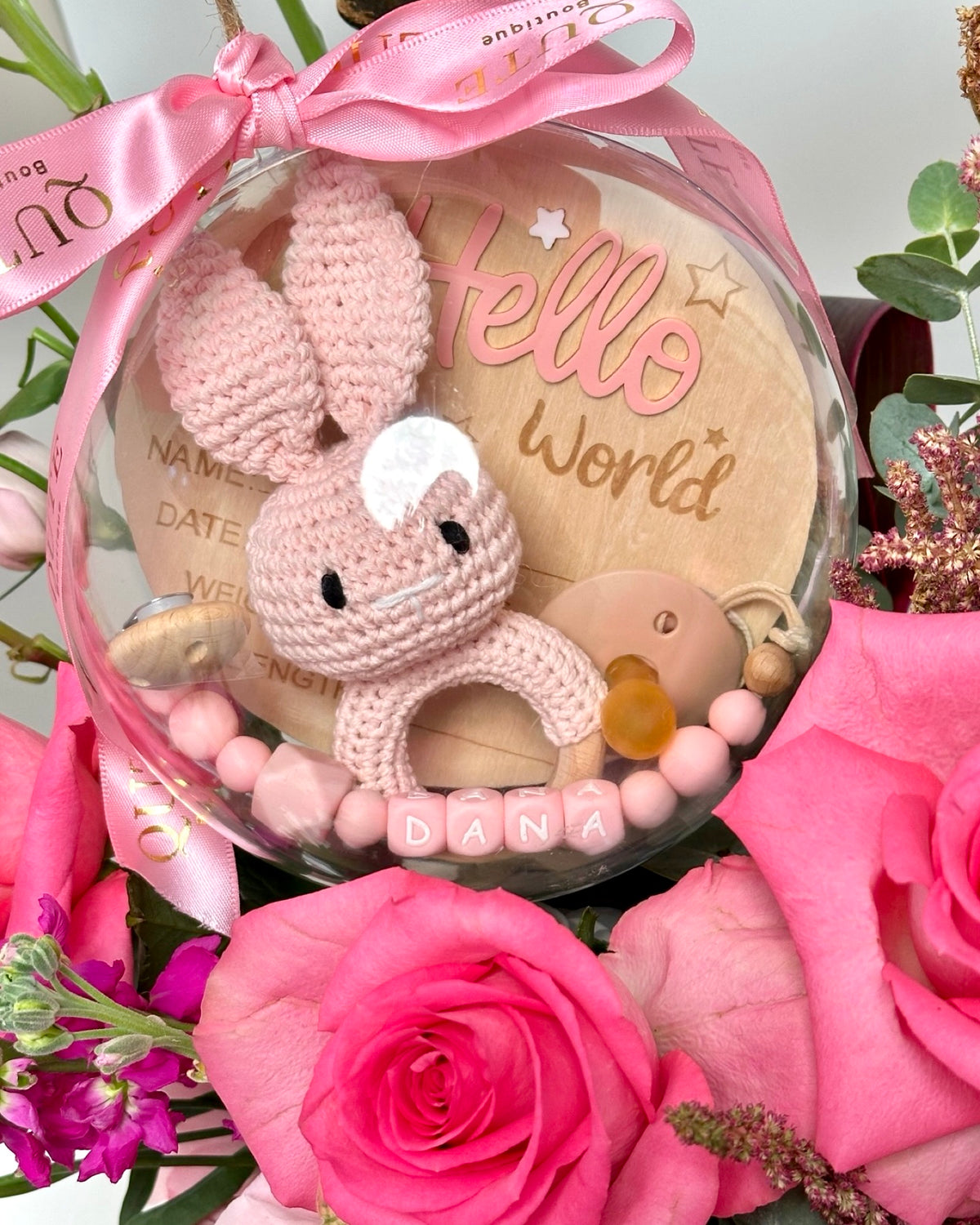 Same-day baby girl gift box featuring luxury pink roses and an acrylic keepsake bubble packed with custom newborn items for welcoming a new baby.   