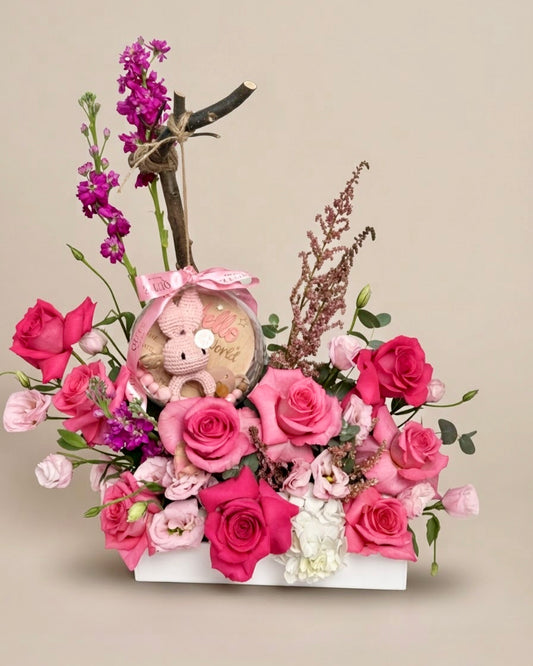 Same-day baby girl gift box featuring luxury pink roses and an acrylic keepsake bubble packed with custom newborn items for welcoming a new baby.   